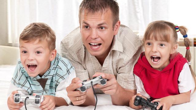 A Dad And His Kids Happily Play Video Games Together. They Have To.