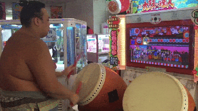 A Sumo Dude Playing A Japanese Arcade Game