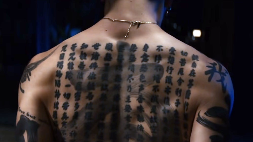 A close-up of MIyavi's backpiece appears in Kate.  (Image: Netflix/Kotaro Sato/YouTube)