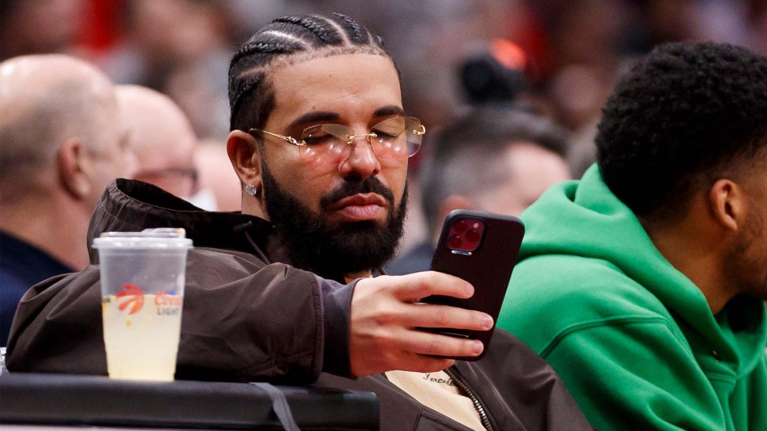 Drake on his phone, maybe posting porn?  (Photo: Cole Bursto, Getty Images)
