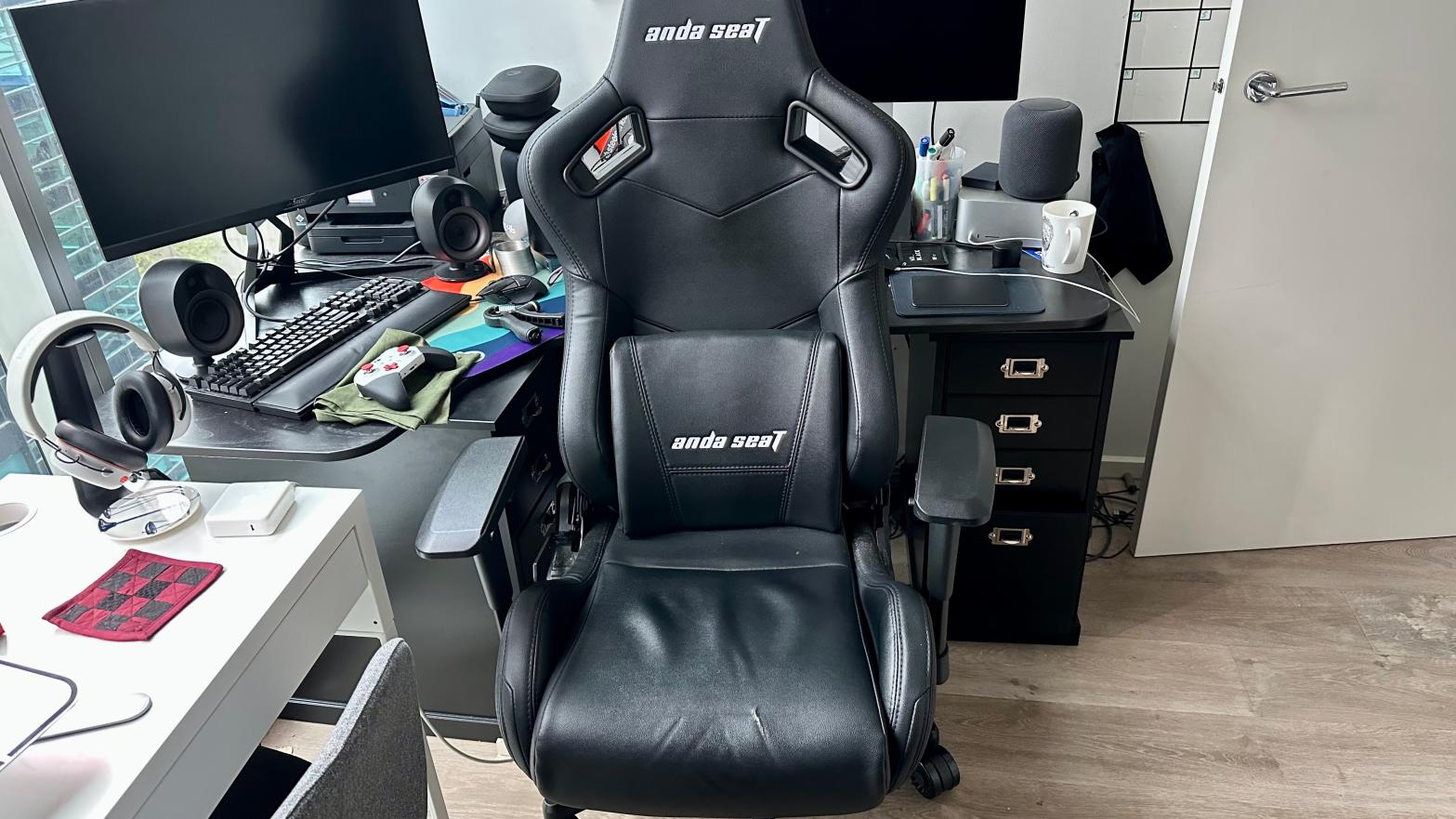 A gamer chair with a cracked seat in a messy home office. Don't judge me.