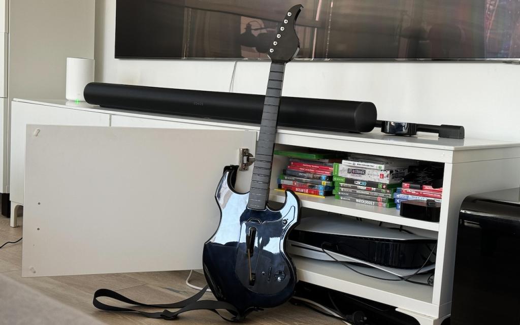 Rifgfmaster guitar controller next to a playtstation in front of a tv